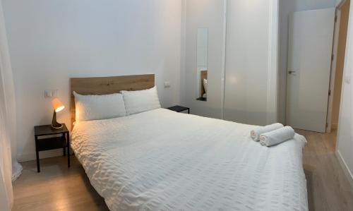 a bedroom with a large white bed with white sheets at Atocha Reina Sofia in Madrid