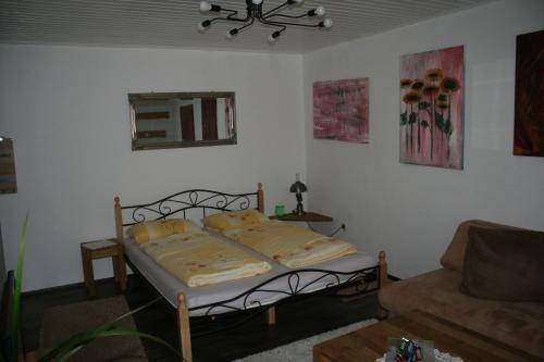 a small bedroom with a bed and a couch at Felsenland-Apartment in Ludwigswinkel