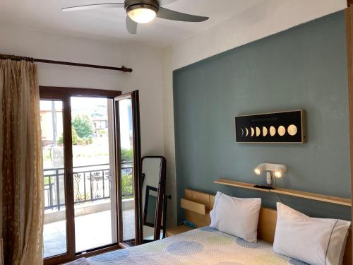 a bedroom with a bed with a ceiling fan and a balcony at Kristel in Ierissos
