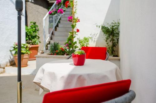una mesa con dos sillas rojas y una planta en ella en Dream Apartment Solitudo, en Dubrovnik