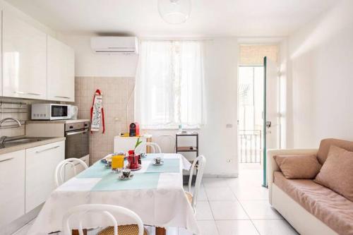 uma cozinha branca com uma mesa e um sofá em Stella Marina em Scilla