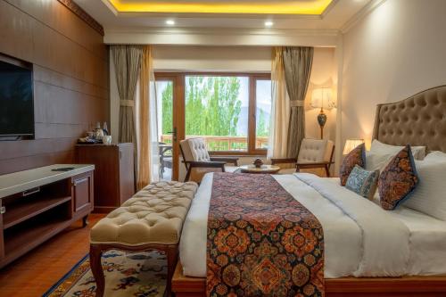 レーにあるHotel Gyalpo Residency - A Mountain View Luxury Hotel in Lehの大きなベッドとテレビがあるホテルの部屋