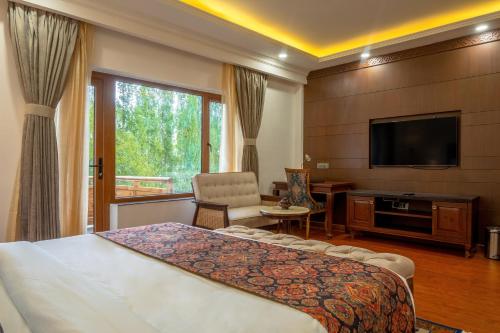 a hotel room with a bed and a flat screen tv at Hotel Gyalpo Residency - A Mountain View Luxury Hotel in Leh in Leh