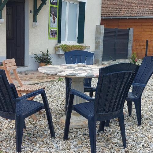 une table et quatre chaises assises autour d'une terrasse dans l'établissement Charmant appartement proche Carcassonne, à Montgradail