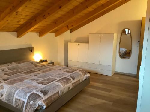 um quarto com uma cama grande e um espelho em Passione Dolomiti em Romeno