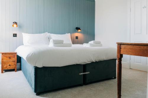 a large bed with white sheets and pillows in a bedroom at Bryn Berwyn Country House Tresaith in Penbryn