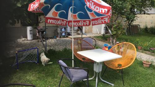 a table and chairs under an umbrella in a yard at Apartman Struga in Struga