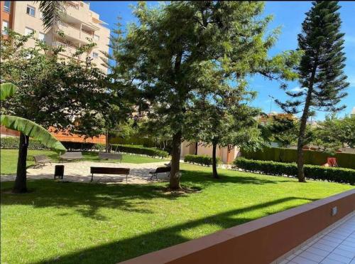un parc avec un banc et des arbres dans l'herbe dans l'établissement Jardines de Sinia, à Los Mártires