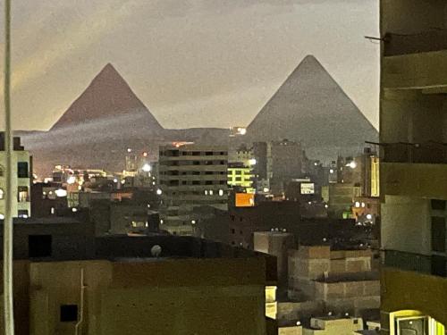 a view of the pyramids in a city at night at Luxury , apartment for business trips or student in Cairo