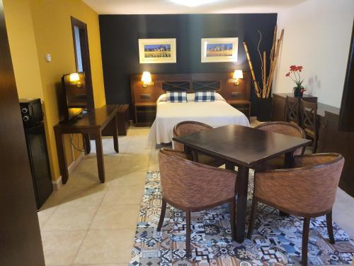 a hotel room with a bed and a table and chairs at HOTEL MASIA EL MOLINETE in Mora de Rubielos