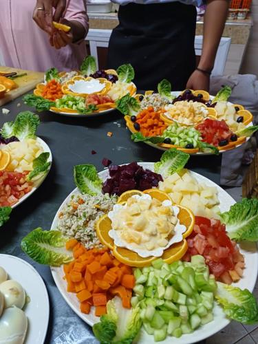 a table topped with plates of different types of food at Dounia Hostel in Tinerhir