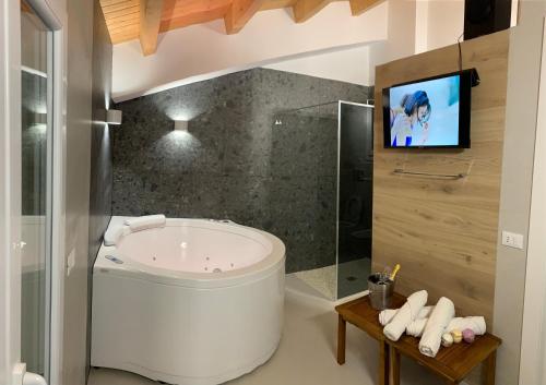 La salle de bains est pourvue d'une baignoire et d'une télévision murale. dans l'établissement LA MAIOLICA, à Pozzallo
