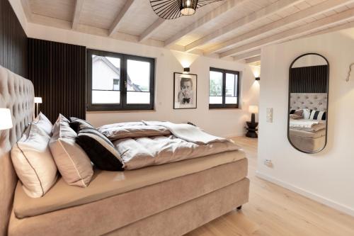 ein Schlafzimmer mit einem großen Bett mit Kissen in der Unterkunft LOFT19 Neu Design Luxus Maisonette Balkon für 2 Personen in Traben-Trarbach