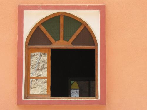 a window in a pink frame on a wall at Dounia Hostel in Tinerhir