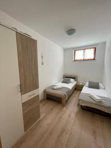 a room with two beds and a cabinet in it at Apartment Sotlar in Izola
