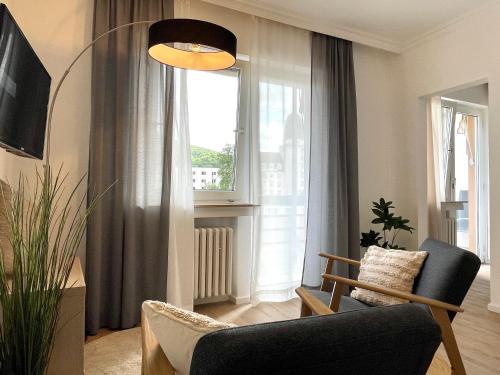 ein Wohnzimmer mit einem Stuhl und einem Fenster in der Unterkunft AhrPart Hotel Central in Bad Neuenahr-Ahrweiler