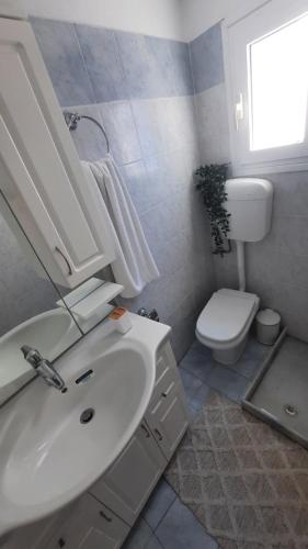 y baño con lavabo blanco y aseo. en Cyclops apartment, en Serifos Chora
