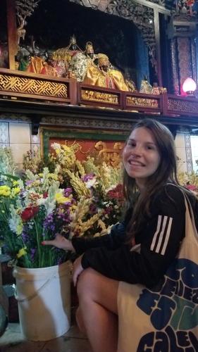 a woman sitting next to a bunch of flowers at CoffeeBunk Hostel in Tangerang