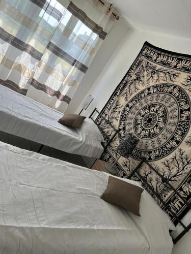a bedroom with two beds and a wall mural at Chez Chris in Libourne