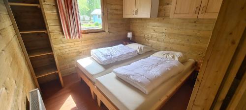 a room with two beds in a wooden cabin at Vakantiepark 't Urkerbos - 5 persoons Brabantse blokhut in Urk