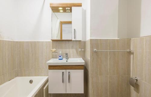 a bathroom with a sink and a mirror and a tub at Appartement 26 ensoleillé à 5 min de la plage El Jadida Piscine à 15km de l'appartement in El Jadida