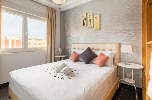 a bedroom with a large white bed with flowers on it at Appartement 26 ensoleillé à 5 min de la plage El Jadida Piscine à 15km de l'appartement in El Jadida