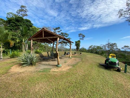 a park with a bench and a pavilion and a green car at Hotel Los Cielos Del Caribe in Cahuita