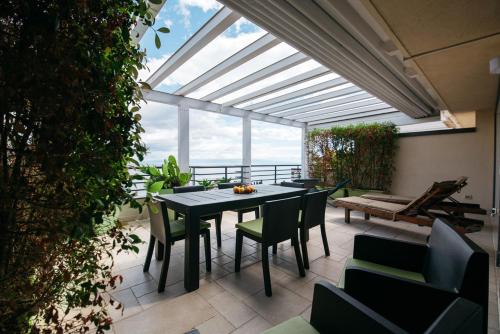 un patio con mesa, sillas y una ventana grande en Taormina Romantic Apartment by Taormina Holidays, en Taormina