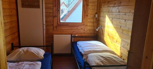 two beds in a small room with a window at Vakantiepark 't Urkerbos - 4 persoons Brabantse blokhut in Urk