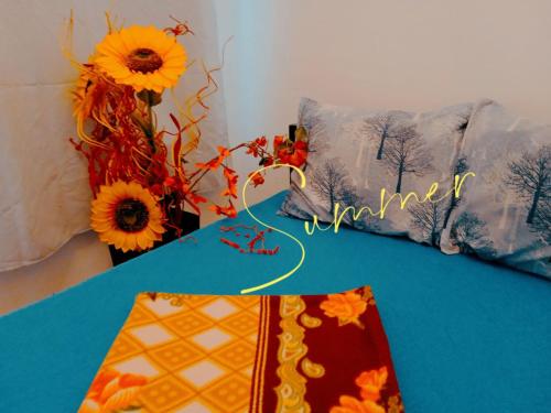 una mesa con 2 almohadas y una mesa azul con flores en STUDIO Eva, en Sajmište
