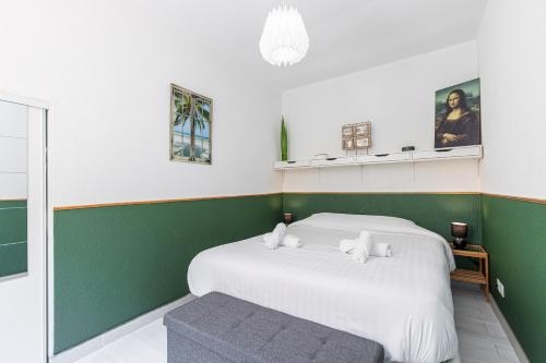 - une chambre verte et blanche avec un lit et un banc dans l'établissement COCOON BEACH Central Proche Mer, à Nice