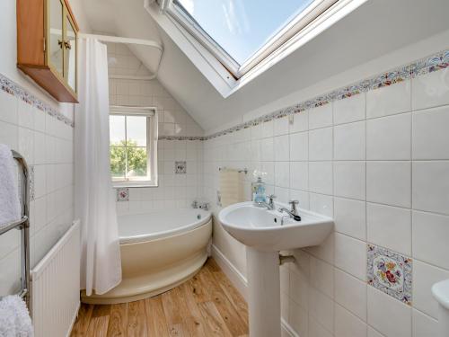 a bathroom with a sink and a bath tub and a skylight at Gunpowder House in Mickleby