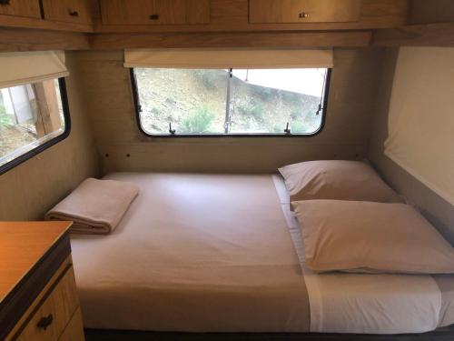 een bed in een kleine kamer met een raam bij Caravanes de Provence in Aiglun