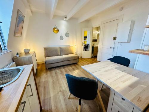 une cuisine et un salon avec une table et un canapé dans l'établissement Studio Hissez Haut - idéalement placé, plage, restaurants, commerces, à Trouville-sur-Mer