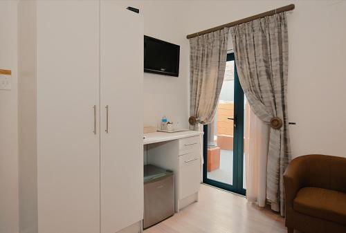 a room with a desk and a tv and a chair at Albatross Guest House Bantry Bay in Cape Town