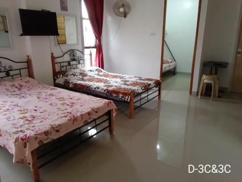 a room with two beds and a flat screen tv at DCAR Residences - Transient House in Tanza