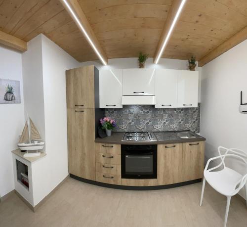a kitchen with white cabinets and a stove at L'Antico Pozzo in Pozzallo