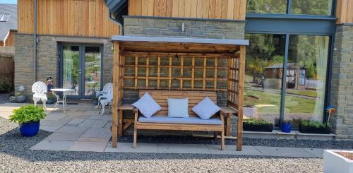 un patio con un banco con almohadas azules. en Solheimir at Strathmore Golf Course, en Blairgowrie