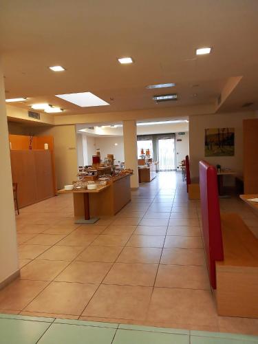 a large room with a lobby with tables and counters at Hotel Grecale - Venturina Terme in Venturina Terme