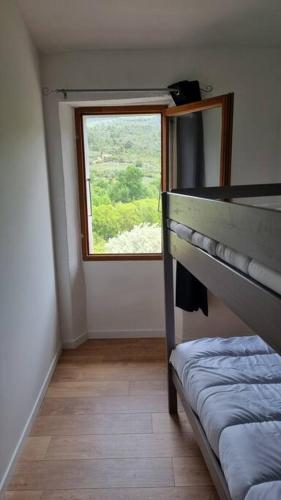 a small room with a bed and a window at Gîte de la confluence in Padern