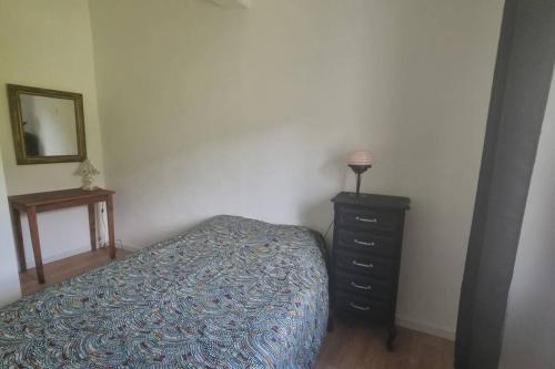 a bedroom with a bed and a dresser and a mirror at Gîte de la confluence in Padern