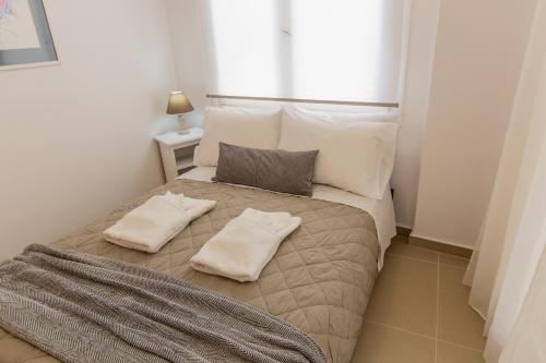 a bedroom with a bed with two pillows on it at Costos Condos NEW 10B 2 Bedrooms Condo in Nafpaktos