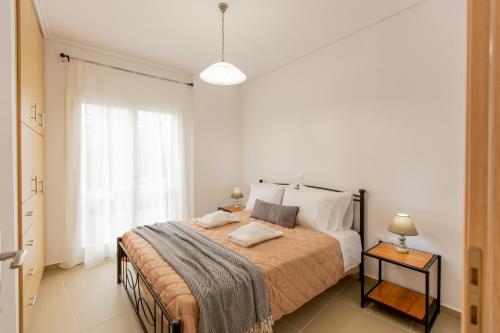 a bedroom with a large bed and a window at Costos Condos NEW 10B 2 Bedrooms Condo in Nafpaktos