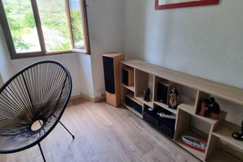 a living room with a chair and a fan at Gîte de la confluence in Padern