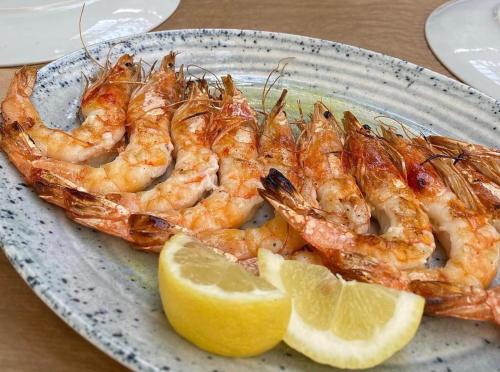 a plate of shrimp with lemon slices on a table at Costos Condos NEW 10B 2 Bedrooms Condo in Nafpaktos