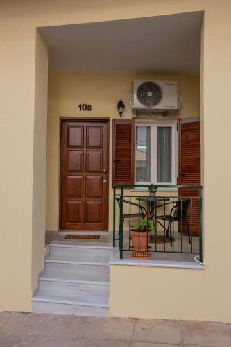 a house with a door and a balcony with a table at Costos Condos NEW 10B 2 Bedrooms Condo in Nafpaktos