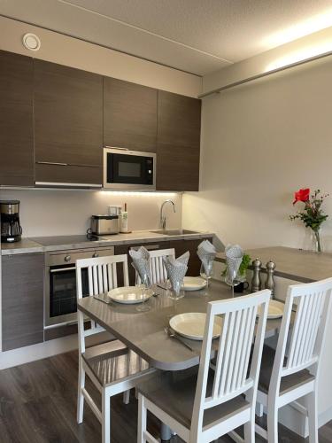 a kitchen with a table and chairs and a kitchen with a counter at Spa Hotel RED in Tahkovuori
