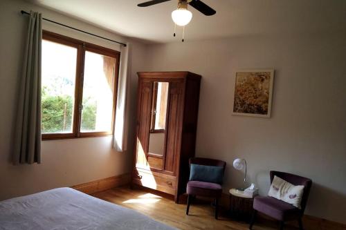 een slaapkamer met een bed en 2 stoelen en een raam bij Spacious villa apartment with mountain view -2 bed in Quillan