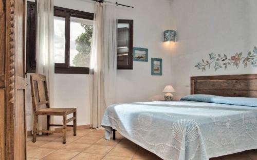 een slaapkamer met een bed, een stoel en een raam bij Vistamare Grande Pevero in Porto Cervo
