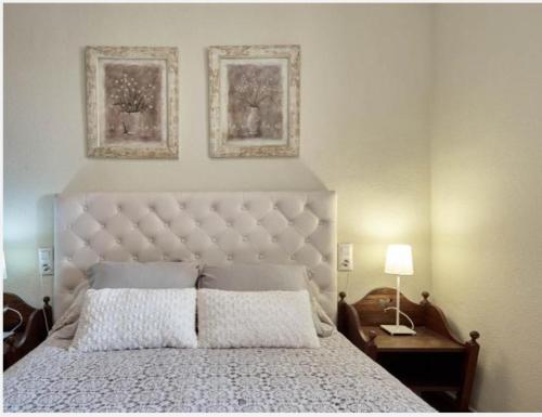 a bedroom with a large bed with two pictures on the wall at Frente a Tabarca in Santa Pola